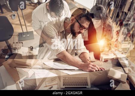 Squadra di seamstresses pronta a spedire il pacchetto al cliente con i vestiti. Doppia esposizione Foto Stock