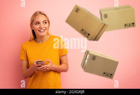 La ragazza carina bionda riceve le scatole veloci di priorità dall'ordine in linea del negozio. Espressione sorpresa e stupita. Foto Stock