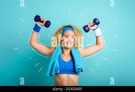 Ragazza si allena con manubri fucsia. Sfondo di colore ciano Foto Stock