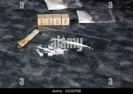 Tossicodipendenza, polvere bianca linea, cocaina, velocità o altri farmaci e siringa con Heroin e il testo STOP. Roba di rifiuto,Addiction,aiuto di fondo di concetto di droga Foto Stock