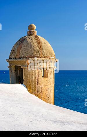 Casa di guardia in pietra sulle pareti di un antico forte in stile coloniale con il mare blu sullo sfondo sul lungomare di Salvador in Bahia Foto Stock