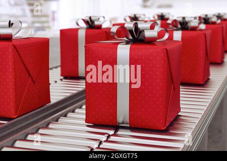 Scatole regalo rosse sul nastro trasportatore in tempo per natale Foto Stock