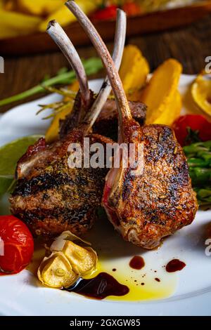 Costolette di agnello marinate in erbe con asparagi verdi e lime Foto Stock