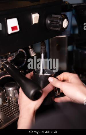 Processo di preparazione della schiuma di latte per cappuccino o latte, riscaldamento e frusta. Barista che fuma il latte nella caraffa Foto Stock