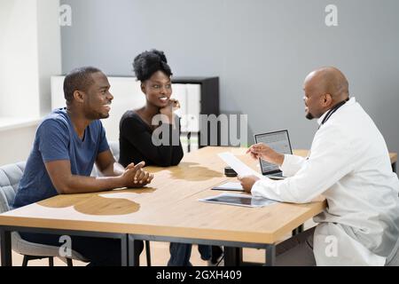 Felice African incinta coppia paziente al medico Foto Stock