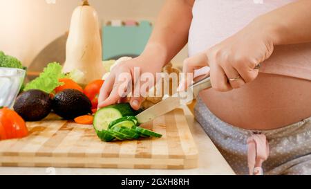 Dolly video di donna incinta in attesa di baby cucina sana insalata di verdure in cucina. Concetto di stile di vita sano e nutrizione durante la gravidanza Foto Stock