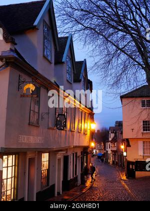 La storica collina acciottolata di Elm a Nightfall con le sue Lanterne dorate e finestre illuminate, Norwich, Norfolk, Inghilterra, Regno Unito Foto Stock