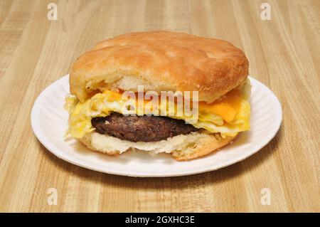 Abbondante sandwich con uova di salsiccia e biscotti al formaggio per la colazione Foto Stock