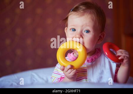 Happy baby con primi denti smilling e giocare con i giocattoli Foto Stock