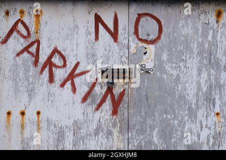 non c'è un cartello di parcheggio sulla porta di un vecchio garage Foto Stock