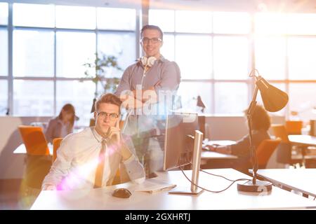 Giovane imprenditore aiutando il suo collega per risolvere il problema del lavoro Foto Stock