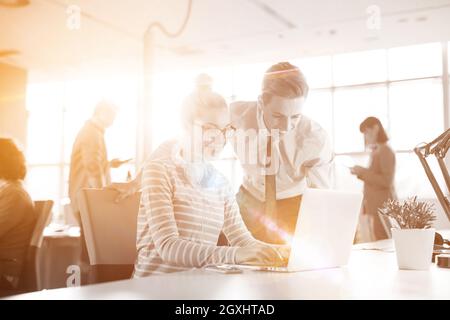 Giovane imprenditore aiutando il suo collega per risolvere il problema del lavoro Foto Stock