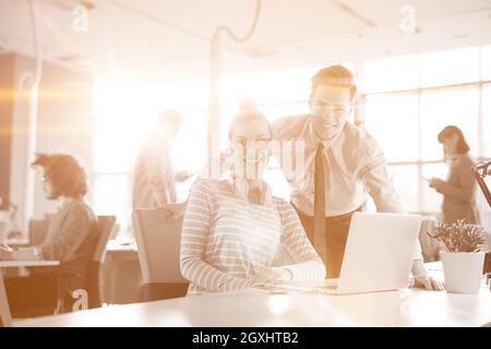 Giovane imprenditore aiutando il suo collega per risolvere il problema del lavoro Foto Stock
