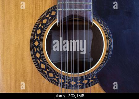 Vista ravvicinata delle corde e buco sonoro di una chitarra Foto Stock
