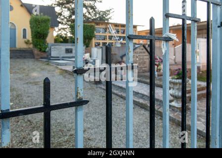 6 ottobre 2021. Quattro Castella. Italia. Porta di ferro con croci di un cimitero. Foto Stock