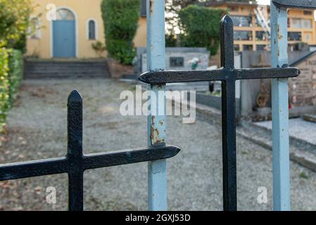 6 ottobre 2021. Quattro Castella. Italia. Porta di ferro con croci di un cimitero. Foto Stock