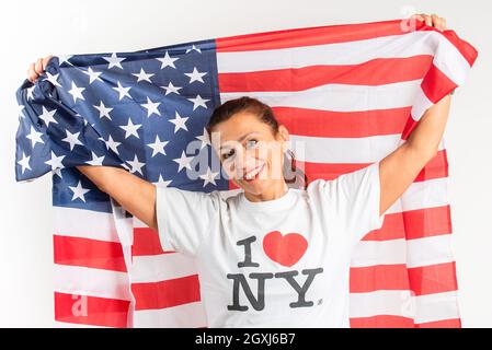 La donna felice gioca con la bandiera americana. Su sfondo bianco. 4th luglio. Grazie. Indipendenza. Giornata dei presidenti. Memorial Day. Giornata del lavoro. Foto Stock