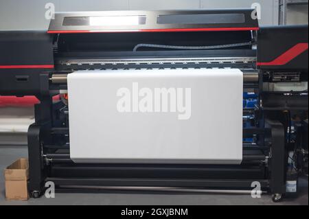 Spazio vuoto di carta bianca su una stampante industriale di grandi dimensioni e una macchina plotter di alta qualità in un ufficio di stampa digitale Foto Stock