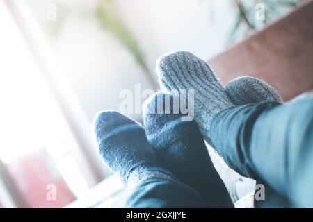 Piedi con i calzini di lana in inverno: matura è rilassante sul lettino Foto Stock