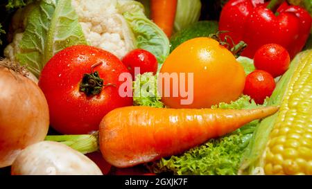 Immagine closeup delle verdure bagnate dal giardino che giace sulla scrivania della cucina. Background per alimenti sani e prodotti GMO free.Dieta nutrizione e fresco v Foto Stock