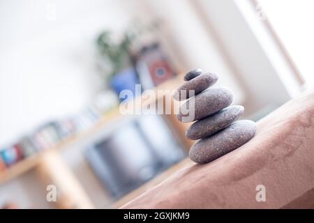 Feng Shui: Cairn di pietra in primo piano, blurry soggiorno in background. Equilibrio e relax. Foto Stock