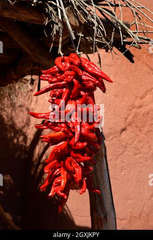Una ristra, un arrangiamento tradizionale di peperoncini rossi del cile, appeso al complesso di storia vivente di El Rancho de Las Golondrinas nel nuovo Messico. Foto Stock