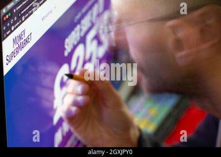 Uomo che guarda il sito internet di Money supermarket Moneysupermarket Foto Stock