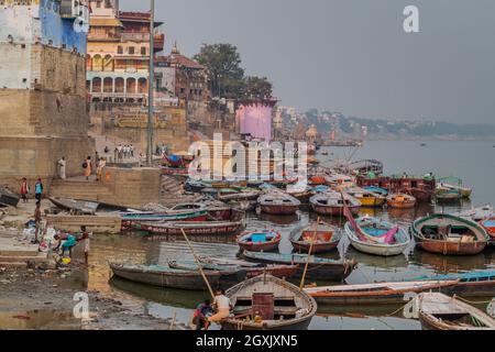 VARANASI, INDIA - 25 OTTOBRE 2016: Piccole barche vicino Ghats scalini che conducono alle rive del fiume Ganges in Varanasi, India Foto Stock