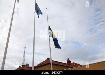 La bandiera svedese a mezza pole, presso la stazione di polizia di Linköping, dopo la morte di due poliziotti a Skåne in relazione ad una missione di protezione e al trasporto dell'artista Lars Vilks, anch'esso morto nell'incidente stradale che si è verificato in quel paese. Foto Stock