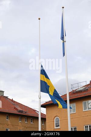 La bandiera svedese a mezza pole, presso la stazione di polizia di Linköping, dopo la morte di due poliziotti a Skåne in relazione ad una missione di protezione e al trasporto dell'artista Lars Vilks, anch'esso morto nell'incidente stradale che si è verificato in quel paese. Foto Stock