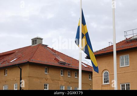 La bandiera svedese a mezza pole, presso la stazione di polizia di Linköping, dopo la morte di due poliziotti a Skåne in relazione ad una missione di protezione e al trasporto dell'artista Lars Vilks, anch'esso morto nell'incidente stradale che si è verificato in quel paese. Foto Stock