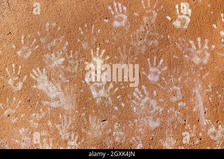 Giochi per bambini con gesso, colore della polvere dalle palme, come le stampe a mano sulla parete ruvida facciata sfondo, infanzia design. Foto Stock