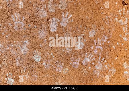 Giochi per bambini con gesso, colore della polvere dalle palme, come le stampe a mano sulla parete ruvida facciata sfondo, infanzia design. Foto Stock