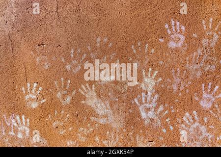 Giochi per bambini con gesso, colore della polvere dalle palme, come le stampe a mano sulla parete ruvida facciata sfondo, infanzia design. Foto Stock