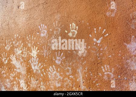 Giochi per bambini con gesso, colore della polvere dalle palme, come le stampe a mano sulla parete ruvida facciata sfondo, infanzia design. Foto Stock