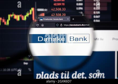 Danske Bank Company logo su un sito web con blurry mercato azionario sviluppi in background, visto su uno schermo del computer attraverso una lente d'ingrandimento Foto Stock