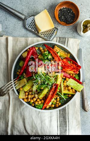 Ciotola di cetriolo e insalata di rucola con ceci, pepe rosso, melanzane e parmigiano Foto Stock