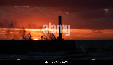 Aberystwyth, Ceredigion, Galles, Regno Unito. 5 ottobre 2021 tempo britannico. Un fotografo gode l'ultimo del sole mentre la tempesta inizia nella città costiera di Aberystwyth. © Rhodri Jones/Alamy Live News Foto Stock