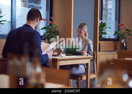 La gente di affari riuniti in un ristorante moderno, coppia romantica con cena e prendere drink dopo il lavoro Foto Stock