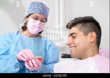 Supporto ortodontista invisibile per l'allineamento dei denti. In clinica mostra i dispositivi di allineamento in plastica trasparente rimuovibili dal paziente o l'uso e il beneficio di invisalign. Foto di alta qualità. Foto Stock