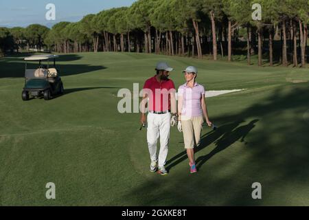 Coppia giovane per raggiungere a piedi il foro successivo sul campo da golf. l uomo che trasportano borsa da golf Foto Stock