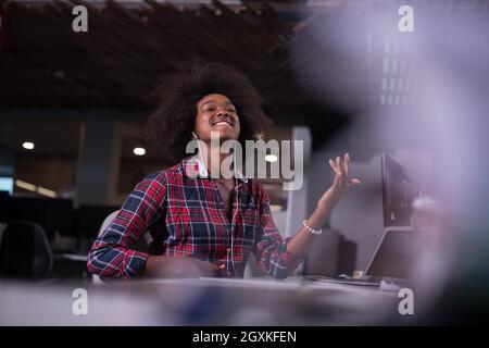 Ritratto di un giovane di successo americano africano bella donna che gode di una spesa di qualità e gioiosa del tempo mentre si lavora in un grande ufficio moderno Foto Stock