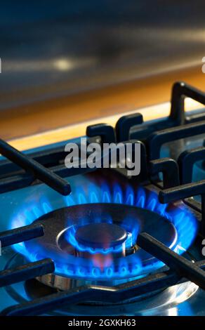 Gas che brucia con fiamme blu sul bruciatore di una stufa a gas. Concetto di impronta di carbonio e prezzo del gas naturale sul mercato Foto Stock