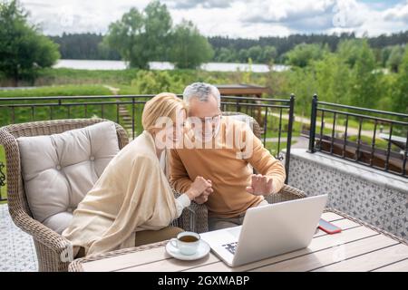 Coppia di sposi felice che salutano qualcuno su Skype Foto Stock