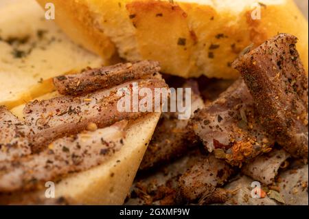 Pancetta fatta in casa tagliata a fette con pepe e pane affettato, primo piano, fuoco selettivo Foto Stock