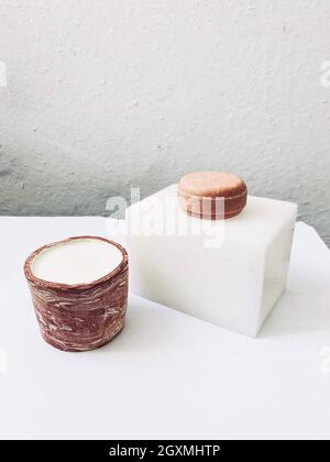 Candela di soia e un solido shampoo bar su un tavolo Foto Stock