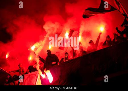 I teppisti con maschera di torce di contenimento nel fuoco mentre a sostenere la loro squadra durante una partita a Stadium Foto Stock