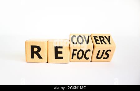 Simbolo di rifocalizzazione e recupero. L'uomo d'affari girò i cubi e cambiò la parola 'focus' in 'Discovery'. Bella tavola bianca, sfondo bianco. Affari Foto Stock