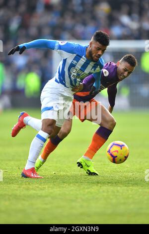Danilo di Manchester City e Elias Kachunga di Huddersfield Town combattono per la palla Foto Stock