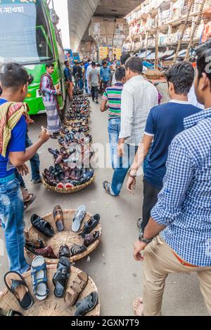 DHAKA, BANGLADESH - 21 NOVEMBRE 2016: Venditore di scarpe con la sua merce su una strada a Dhaka, Bangladesh Foto Stock